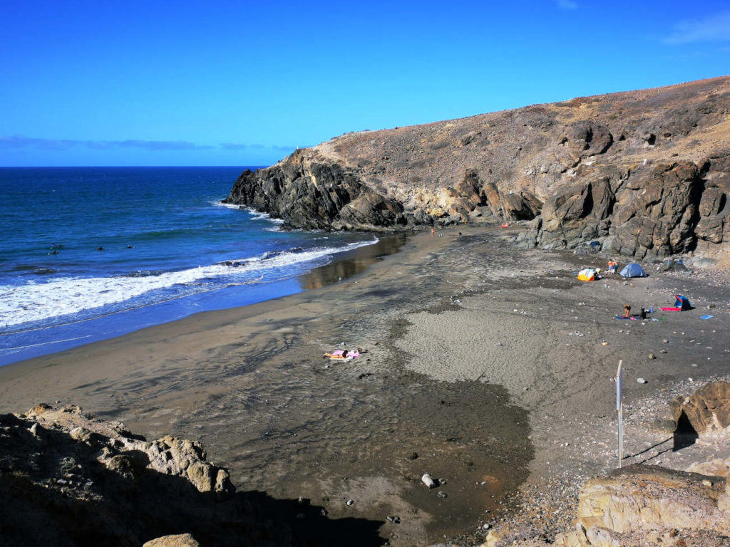Dunkler bis schwarzer feiner Sandstrand am Playa de Pocito Bea